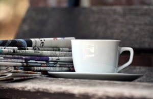 Tasse de café à côté d'une pile de journaux