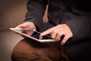 Un homme pointe l'écran d'une tablette tactile