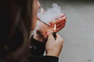 Jeune femme qui s'allume une cigarette