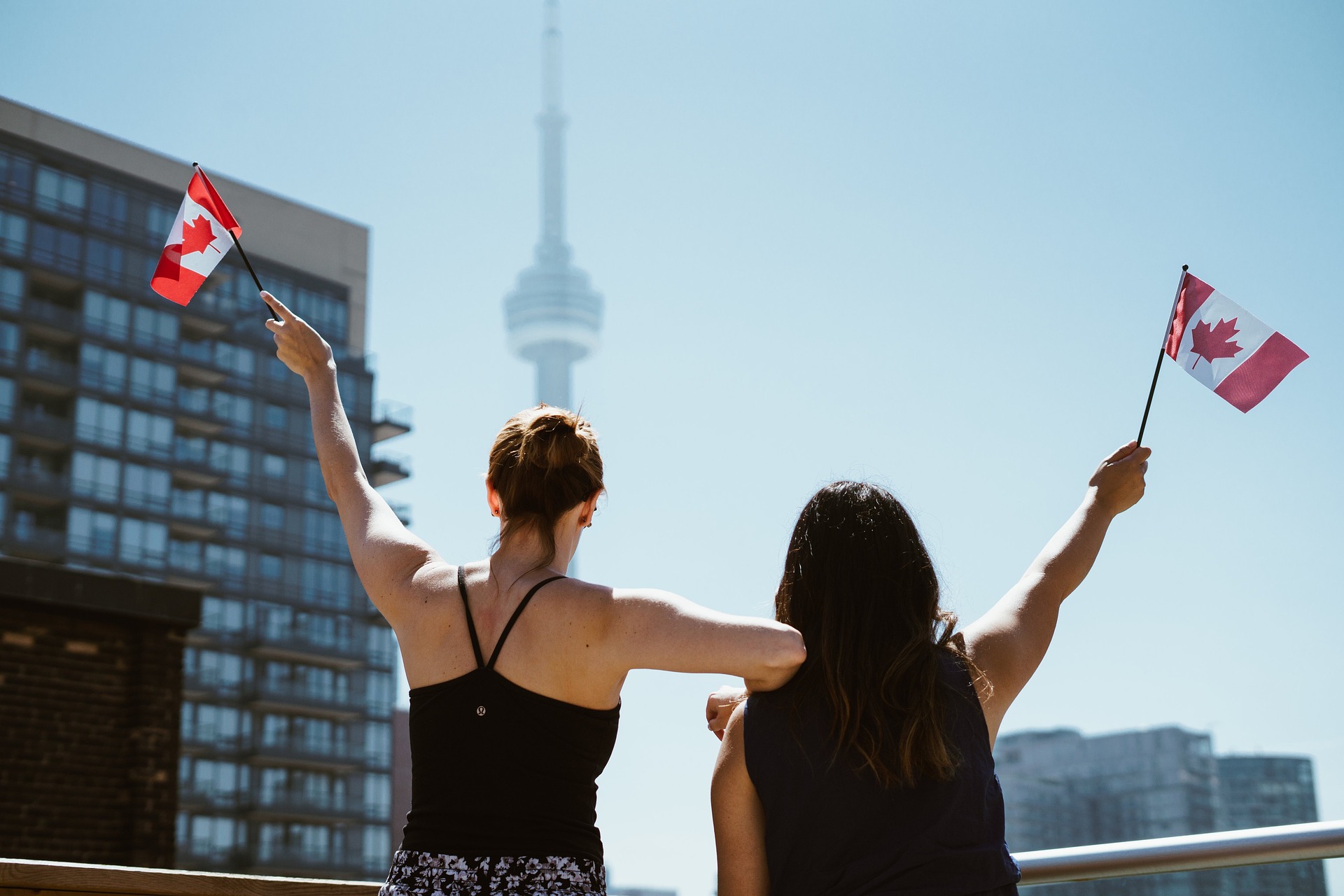 Deux jeunes filles agitent un drapeau canadien