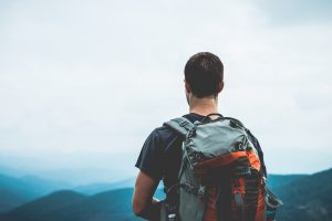 Un homme avec un sac à dos au sommet d'une montagne