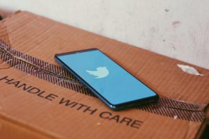 Un téléphone avec le logo Twitter posé sur une boîte