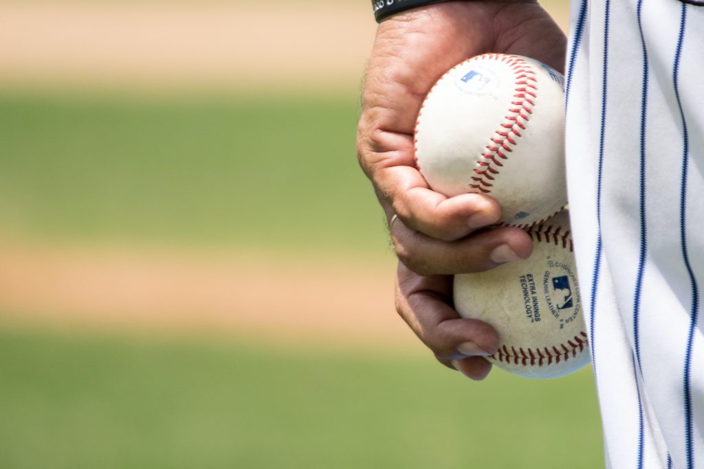 Un lanceur tient deux balles de baseball