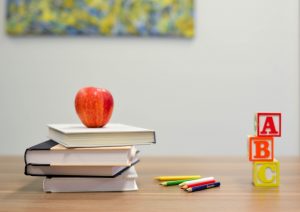 Une pomme posée sur une pile de livres