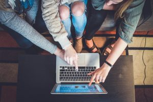 Trois personnes pointent l'ordinateur l'écran d'un ordinateur portable