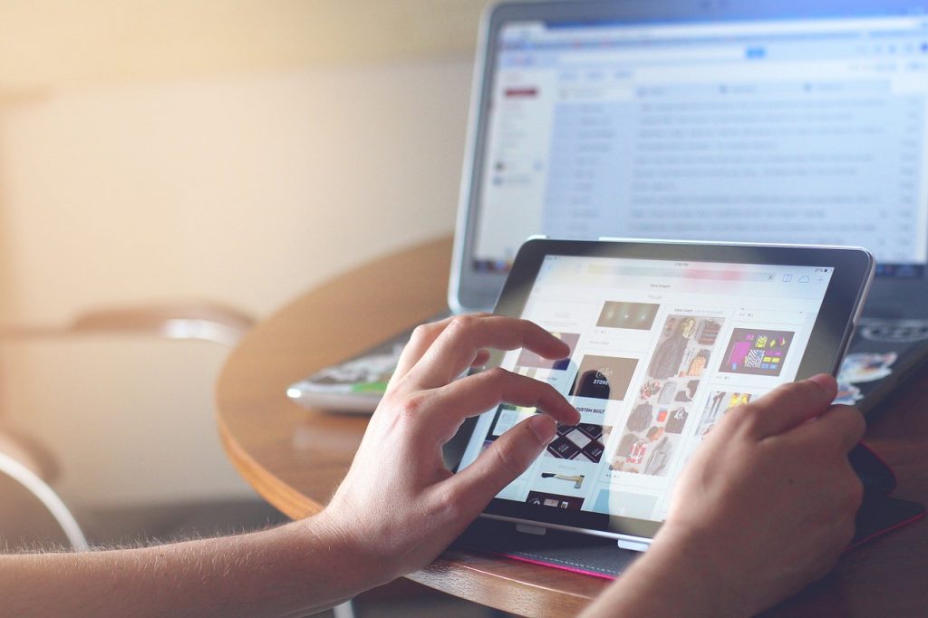 Quelqu'un qui manipule une tablette tactile devant un ordinateur