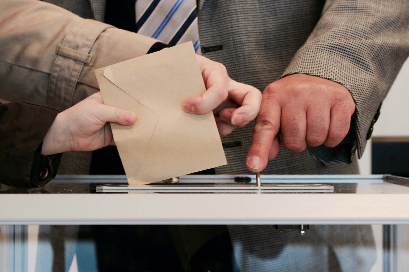 Des personnes debout près d'une table avec un bulletin de vote