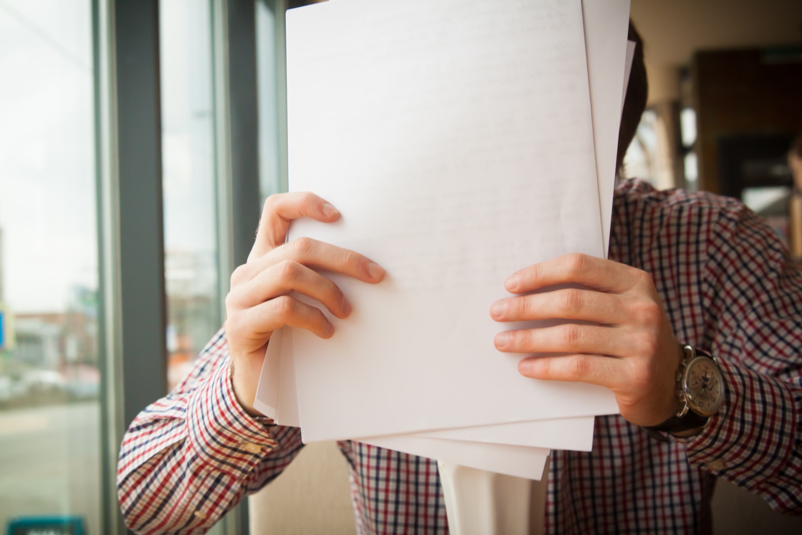 Personne tenant du papier d'imprimante devant son visage