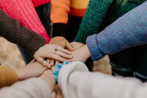 Des personnes qui ont les mains les unes par-dessus les autres