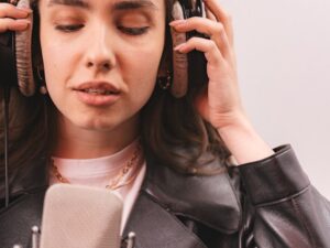 Une femme portant un veston de cuir devant un micro