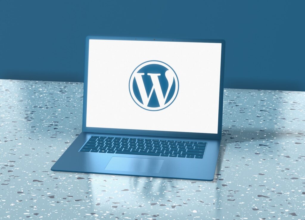 Un ordinateur portable sur l'écran duquel on aperçoit le logo de WordPress