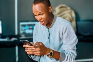 Un homme surpris en regardant son téléphone cellulaire