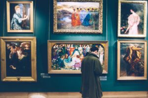 Une personne devant des toiles dans une galerie d'art