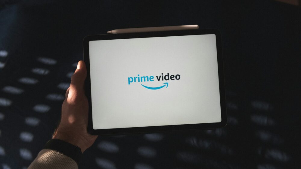 Une personne tient une tablette avec le logo de Prime Video