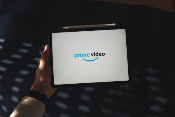 Une personne tient une tablette avec le logo de Prime Video