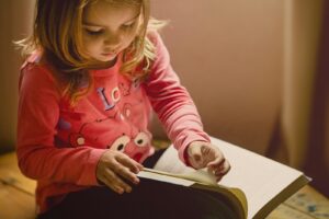 Une fillette d'âge préscolaire tient un livre